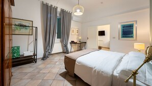 A hotel room with a bed, a desk, a chair, a lamp, and a picture on the wall. - Terme Apartment - Two Bedroom Apartment, Sleeps 4 (Firenze)