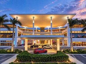 A modern hotel with a multi-level structure, a covered entrance, and a parking area with cars. - Beachfront 2b/2b  Isla Verde  Marbella Oeste (Carolina)