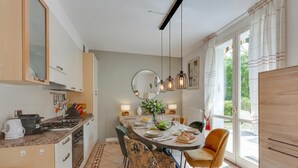 A modern kitchen with a dining area, large windows, and a view of the outdoors. - Villa Apartments - Porto Letizia (Porlezza)