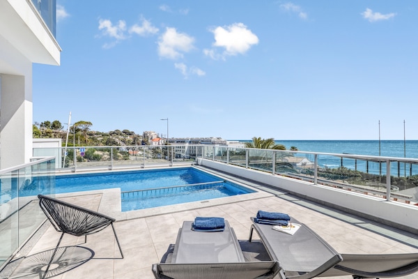 sunloungers and beach towels around the pool and a great sea view