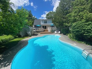 Une piscine avec une maison en arrière-plan.