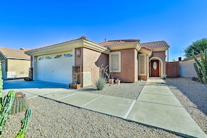 A residential house with a garage, a front door, and a pathway leading to the entrance.