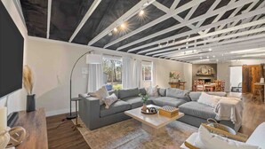 A spacious living room with a large sectional sofa, a coffee table, and a floor lamp. - Serene Getaway Near Baylor and Magnolia Perfect for Relaxation and Exploration (Waco)
