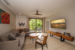 A modern living room with a sofa, round table, and a bench. - Pacifico L517 Casa Khe • 2 BR Resort-Club Condo • Pools, Beach Club Access, Playas del Coco 4 Guests (Provincia de Guanacaste)