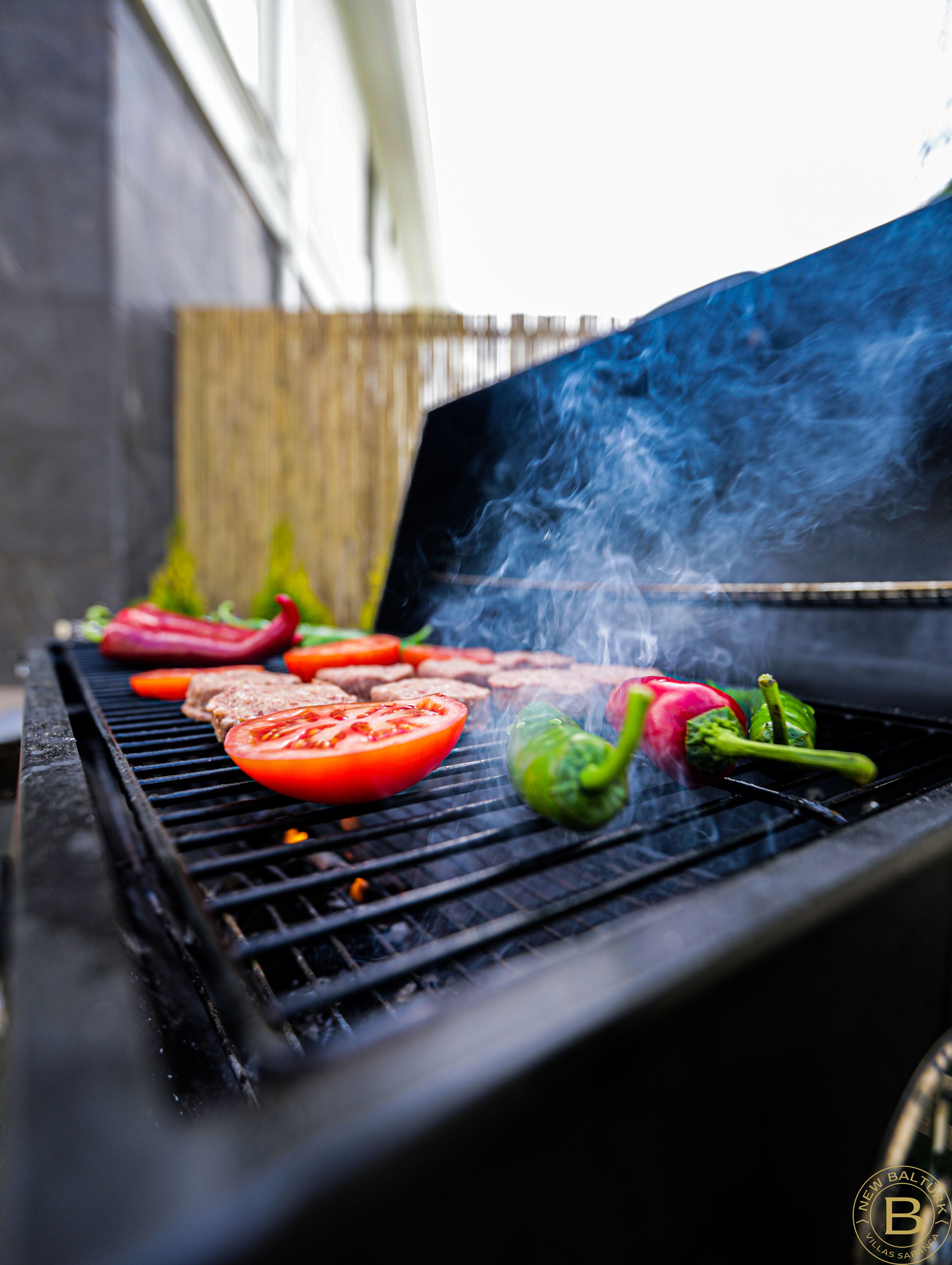 Un barbecue avec divers légumes et morceaux de viande en train de cuire.
