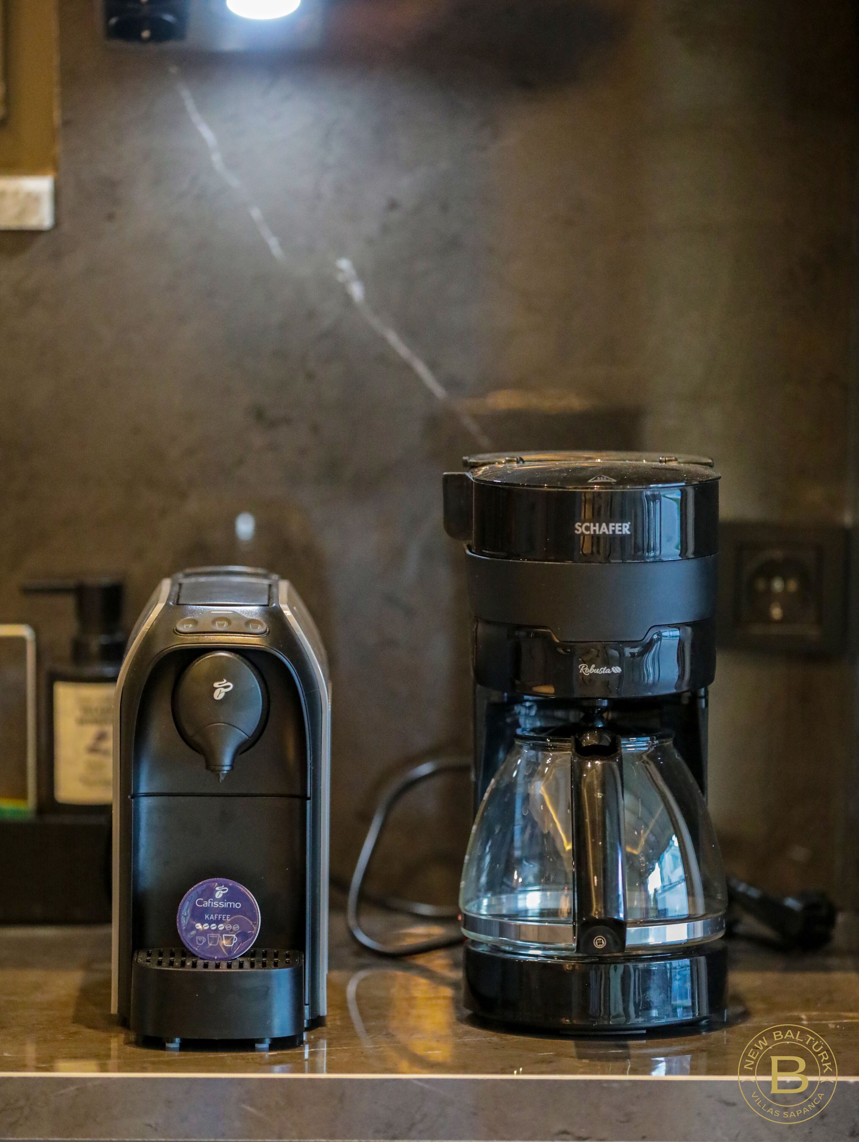 A coffee maker with a Kafissimo capsule and a Schafeder drip coffee maker on a countertop.