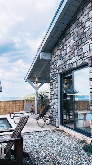 Un bâtiment en pierre doté d’un patio couvert, d’un espace extérieur aménagé pour s’asseoir et d’une piscine.