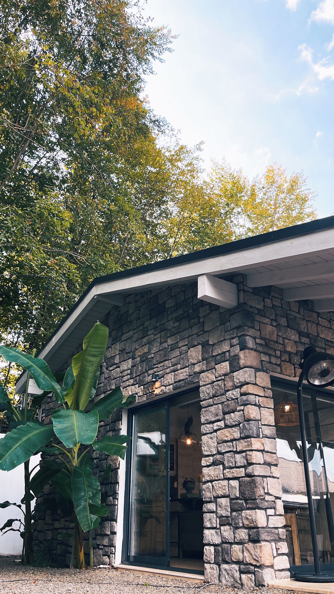 A stone building with a modern design, featuring a large glass door and a stone facade.