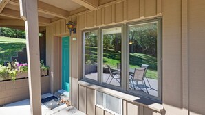 A covered porch with a view of a lawn and patio furniture. - Chanticleer Inn 39 (Eagle River)