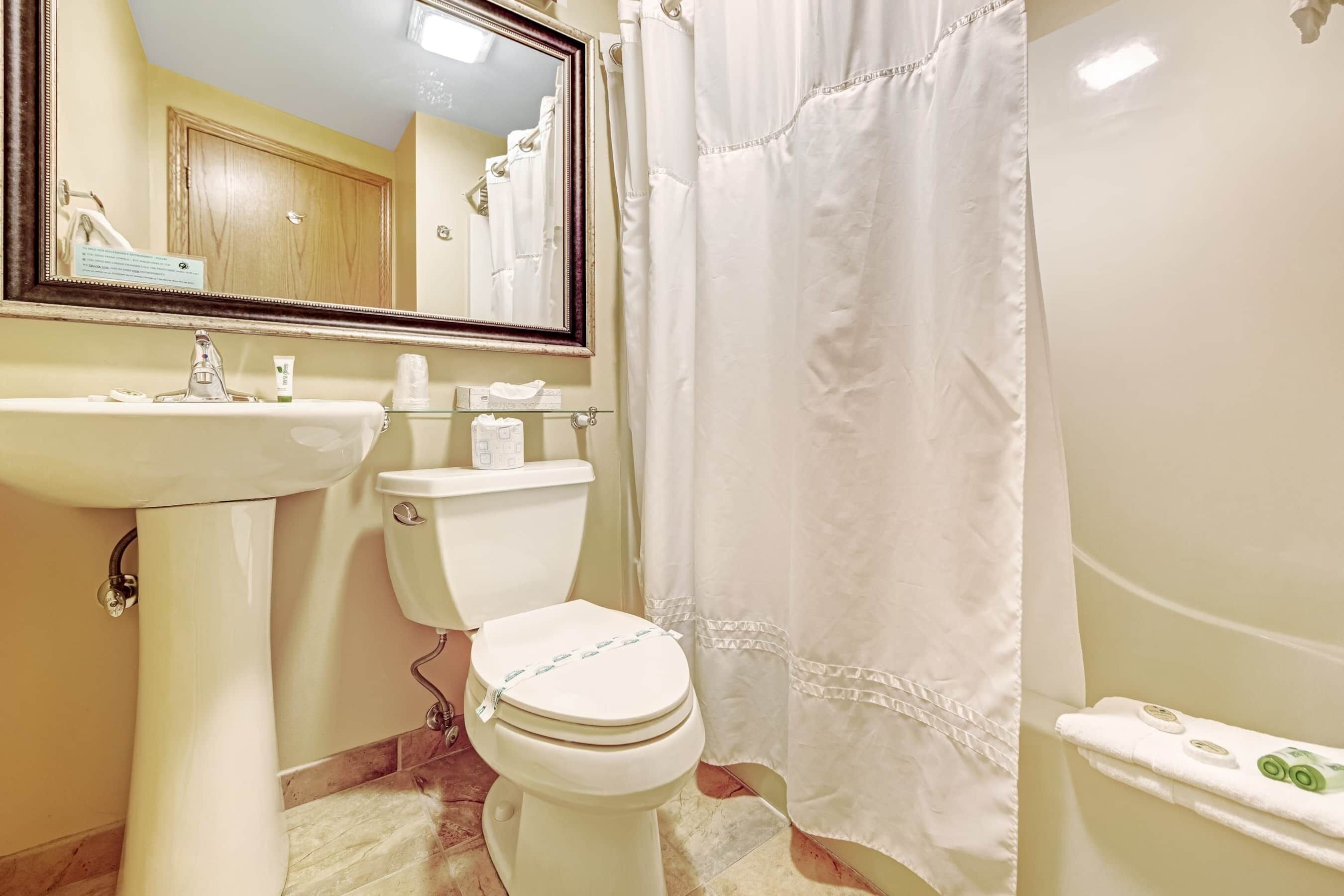 A bathroom with a white sink, toilet, and bathtub.