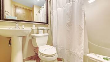 A bathroom with a white sink, toilet, and bathtub.