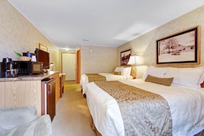 A hotel room with two beds, a desk with a microwave, a television, and a framed picture on the wall. - Chanticleer Inn 54 (Eagle River)