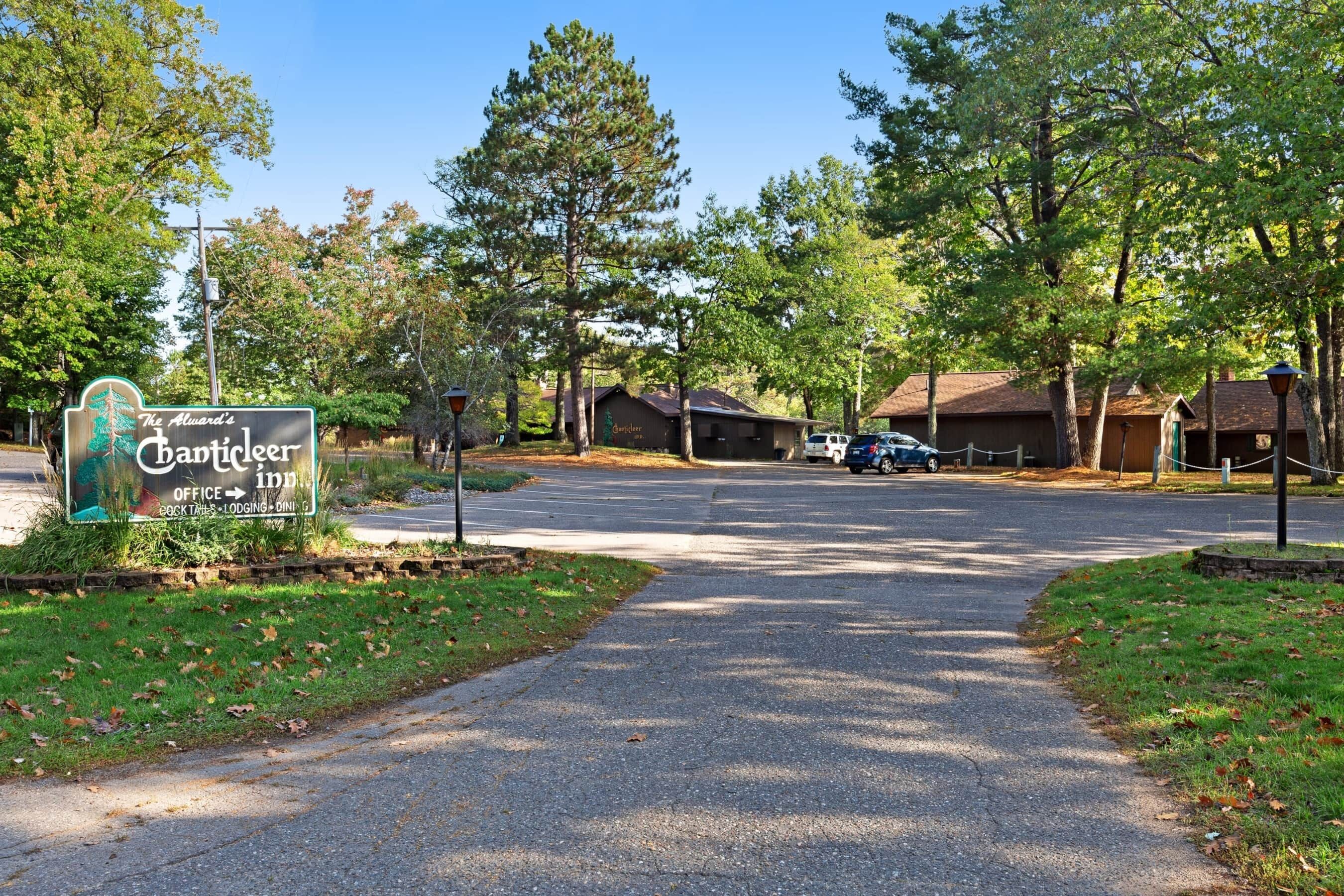 A sign for The Alward's Cabins & Inn with a paved driveway leading to a parking area.