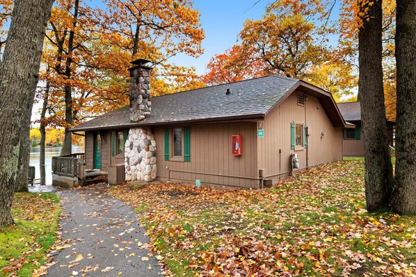 A lodge with a stone chimney, a small porch, and a number 7 sign. - Chanticleer Inn Villa 7 (Eagle River)