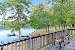 A wooden deck with a view of a lake and trees. - Chanticleer Inn Villa 8 (Eagle River)