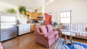A compact living space with a kitchenette, a sofa, and a dining area. - sweet little casita (Santa Fe)