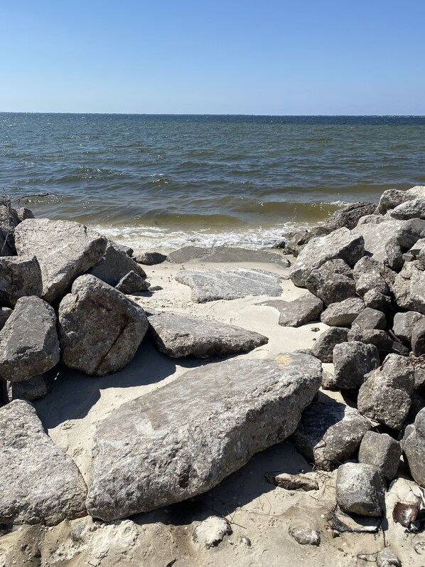 A rocky shoreline with large boulders and a view of the ocean.