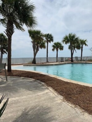 A swimming pool with palm trees and a fence. - New Windmark Phase 1 home on the beach with amazing views. (Port St. Joe)