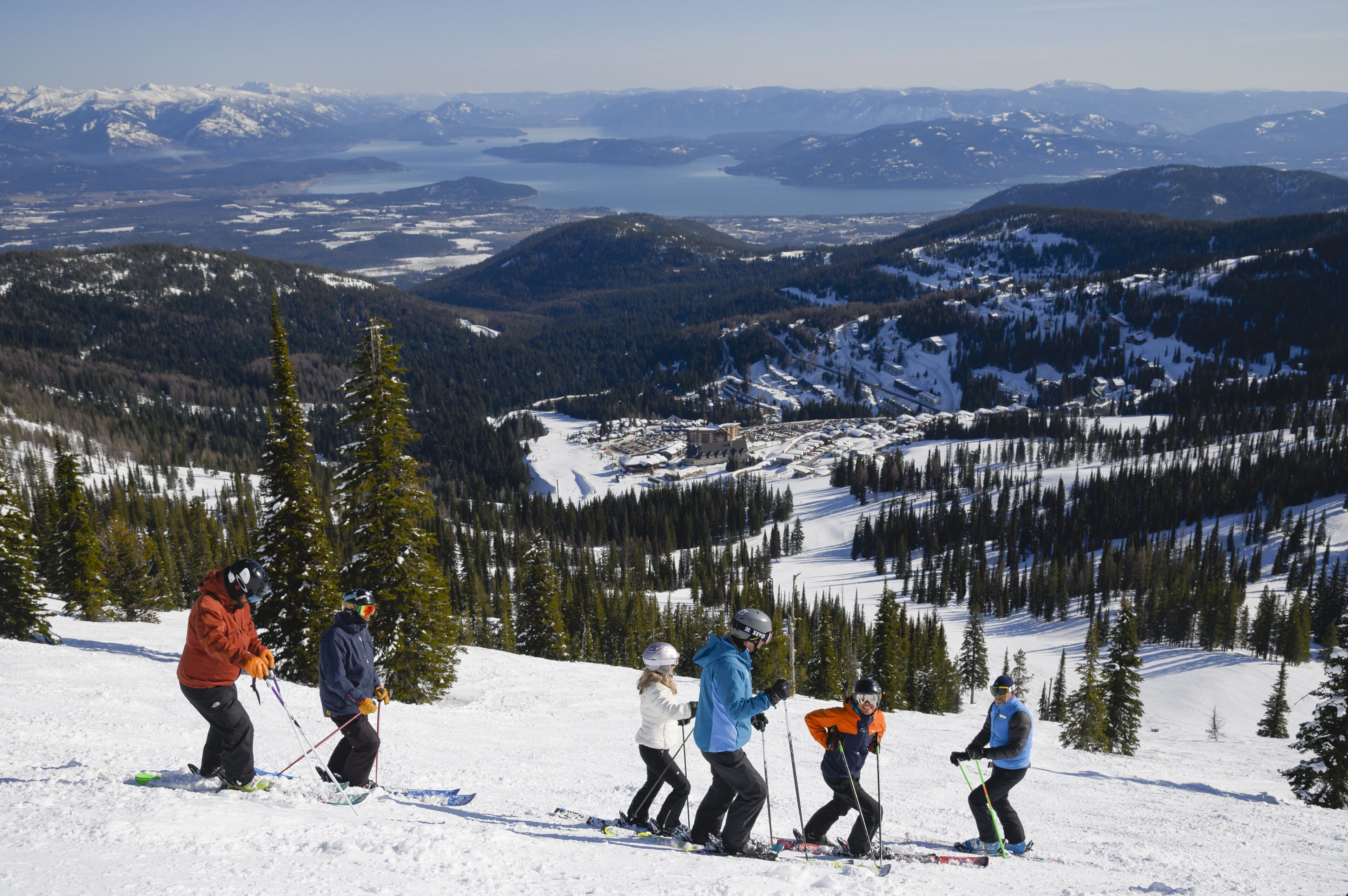 Un groupe de skieurs sur une pente enneigée, avec une vue panoramique sur le paysage environnant.