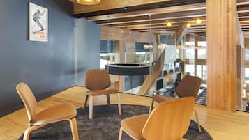 Een modern interieur met houten vloeren, een ronde tafel en drie bruine stoelen.