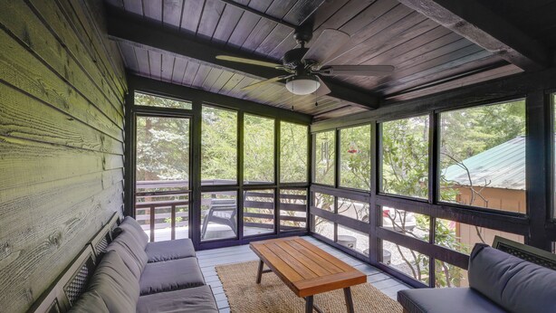 A covered porch with a ceiling fan, wooden walls, and large windows offering views of the outdoors. - Newland Gem in Golf Community w/ Pool Access! (Newland)