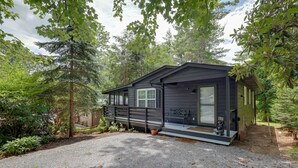 A cabin with a gravel driveway, surrounded by trees. - Newland Gem in Golf Community w/ Pool Access! (Newland)