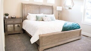 A bedroom with a bed, nightstand, and dresser. - New family-sized home in the heart of old-town Nampa -- walking distance to NNU! (Nampa)