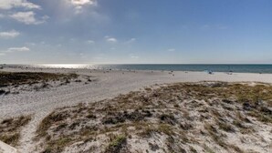 A beach with a sandy foreground and a clear sky.