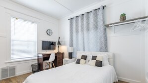 A neatly arranged bedroom with a bed, a desk, and a chair. - 8032-3 blocks to Mayo-SALE Cute Studio on Main Floor 8032 (Rochester)