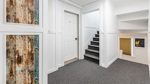 A hallway with a white door labeled '6', a staircase, and a small window with blinds. - 8032-3 blocks to Mayo-SALE Cute Studio on Main Floor 8032 (Rochester)