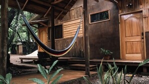 A wooden cabin with a hammock, wooden steps, and a small potted plant. - RusTeak Living Boutique Hotel Mango Studio - a Refuge in Nature (Provincia de Guanacaste)