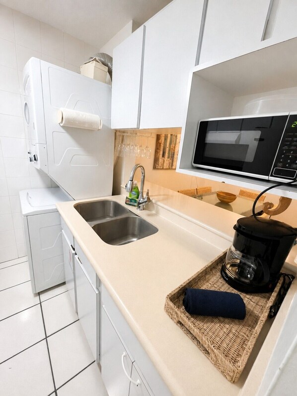 A modern kitchen with a double sink, a microwave, and a coffee maker on the counter.