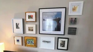 A wall with multiple framed pictures of various sizes and styles.