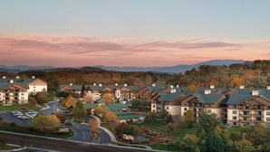 A resort with multiple buildings, a winding road, and a mountainous backdrop. - 1BD/Sevierville - Smoky Mountains Resort w/pools! (Sevierville)