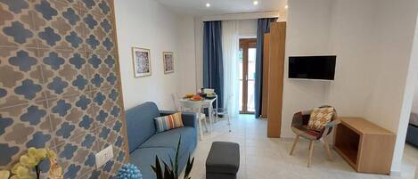 Una sala de estar moderna con un sofá, una mesa de centro y un televisor montado en la pared.