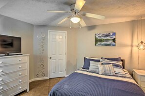 A bedroom with a bed, a ceiling fan, a TV, a dresser, and a door. - Albany Home < 1 Mi to Dale Hollow Lake! (Albany)