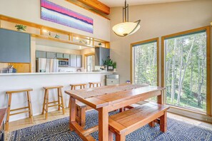 Enjoy meals and socializing in this kitchen with a central island, refrigerator, microwave, and sink, plus a dining table and stools.