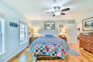 A bedroom with a bed, a ceiling fan, a wooden dresser, and a window with blinds. - Waterfront Gladwin Home w/ Deck + Fire Pit! (Gladwin)