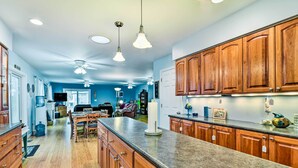 A spacious kitchen with wooden cabinets, granite countertops, and pendant lighting. - Waterfront Gladwin Home w/ Deck + Fire Pit! (Gladwin)