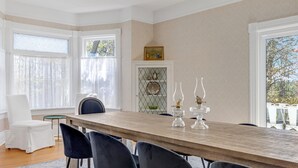 A dining area with a wooden table, black chairs, and two glass lamps. - The Carrington | 5 Bed Victorian | Pool  and  Hot Tub (Prince Edward)