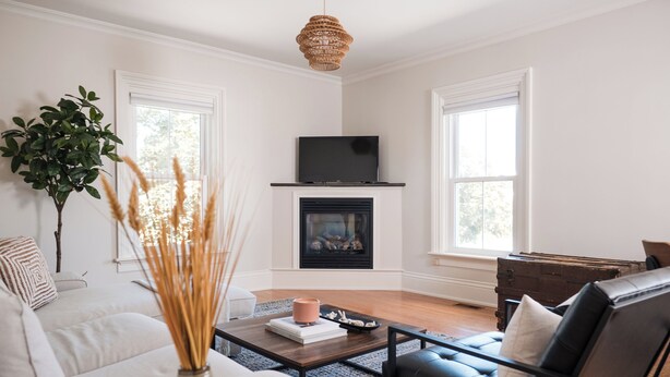 Una sala de estar con chimenea, un sofá, una mesita de centro y un televisor.