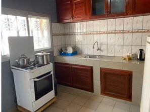 Une cuisine de taille réduite équipée d’une cuisinière à gaz, d’un four et d’un évier.