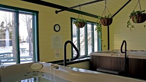 A bathroom with a bathtub, a sink, and a window. There are hanging plants and a clock on the wall. - Okemo Ski in-Ski out @ Winterplace, 3 bdr, 2 ba Condo with Pool, Hot Tub, W/D (Ludlow)