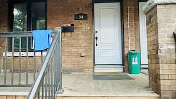 Enter a charming home at 94, where a welcoming porch awaits with a comfortable chair.