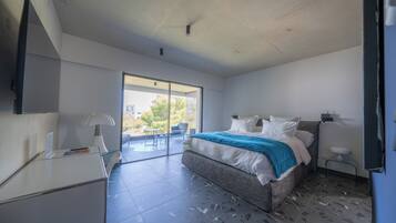 Een moderne slaapkamer met een groot bed, een bureau en een stoel.
