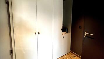 A room with a large wardrobe, a mirror, and a patterned floor.