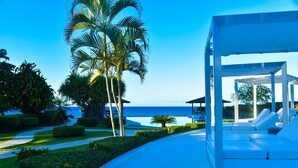 Un resort con piscina, palmeras y vista al océano.
