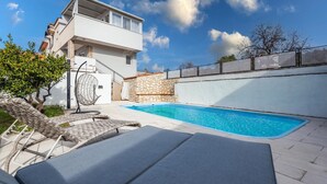 A modern two-story house with a swimming pool, outdoor seating, and a stone wall. - Cozy home in Brodarica (Brodarica)