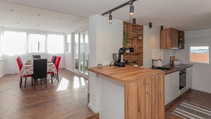 A modern kitchen with wooden cabinets, a built-in island, and pendant lighting. - Cozy home in Brodarica (Brodarica)