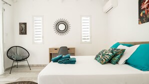 Een slaapkamer met een bed, een stoel, een bureau en een kunstwerk aan de muur.